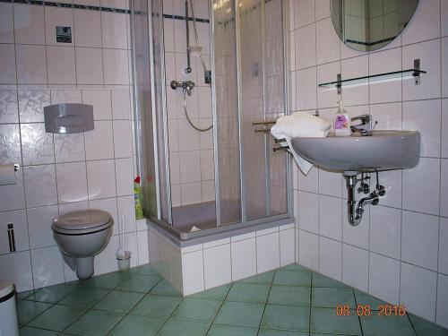 黑灵斯多夫Strandoase-App-04的带淋浴、盥洗盆和卫生间的浴室