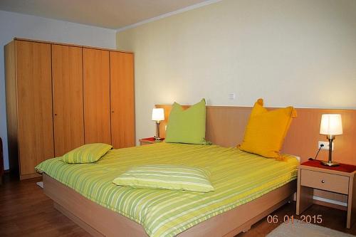 黑灵斯多夫Strandoase-Whg-13的一间卧室配有一张带黄色和绿色枕头的床