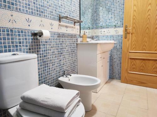 索尔德乌AC Apartaments Pleta Soldeu的蓝色瓷砖浴室设有卫生间和水槽
