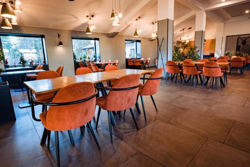 坎皮纳Pensiunea Oscar的餐厅内带桌椅的用餐室