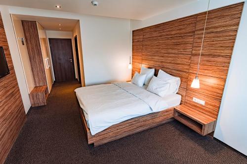 坎皮纳奥斯卡酒店的一间卧室配有一张大床和木制床头板