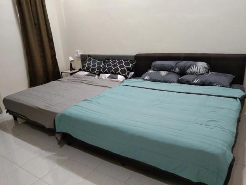 怡保Koolest homestays Meru的一张带蓝色毯子和枕头的床
