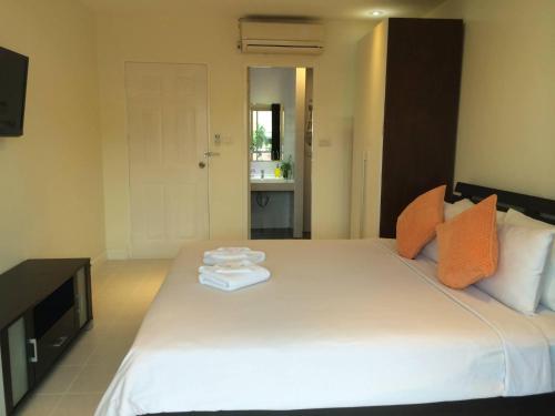 卡塔海滩Glitter House Phuket的卧室配有带毛巾的大型白色床