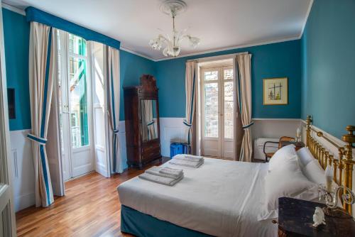 拉古萨I Sogni della Memoria的一间拥有蓝色墙壁的卧室和一张带白色床单的床