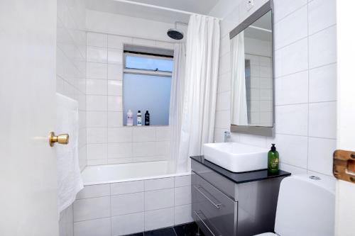 雷克雅未克City view, bright & cozy - Free parking (A4)的白色的浴室设有水槽和浴缸。