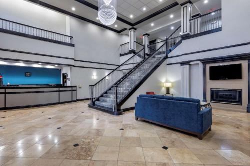 达拉斯I-35E核桃山品质套房酒店的大型客房设有楼梯和蓝色沙发。
