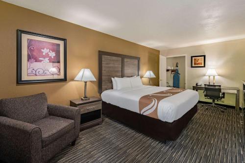 拉夫金Quality Inn & Suites Lufkin的配有一张床和一把椅子的酒店客房