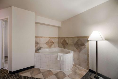 拉夫金Quality Inn & Suites Lufkin的带浴缸和台灯的浴室