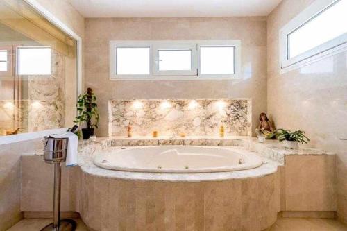 圣埃乌拉利亚Gorgeous Villa near Ibiza centre的大型浴室设有2扇窗户和大浴缸
