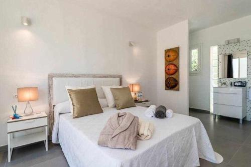 圣埃乌拉利亚Gorgeous Villa near Ibiza centre的卧室配有白色床和毛巾