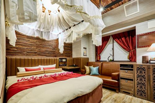 东京Petit Bali Ikebukuro的一间卧室配有一张大床和一张沙发
