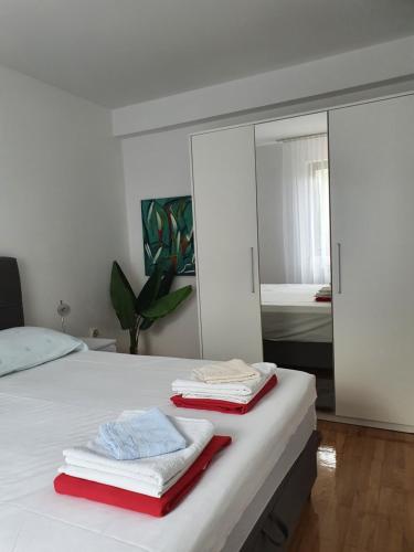 诺瓦利娅Apartmani Nada的卧室配有白色床和毛巾