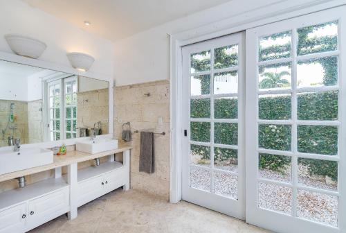 蓬塔卡纳Paradise Luxury Villa with Huge Pool and Jacuzzi的一间带两个盥洗盆和大镜子的浴室