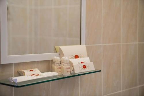 阿斯塔纳Belon Lux Hotel的浴室内的架子,配有肥皂和镜子