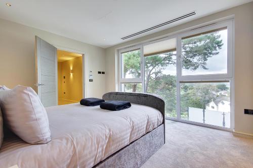 Canford CliffsLuxury 3bd penthouse with roof terrace and hot tub的一间卧室配有一张带两个枕头的床