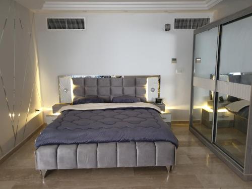 安曼Deir Ghbar-Studio的一间卧室配有一张带蓝色毯子的大床