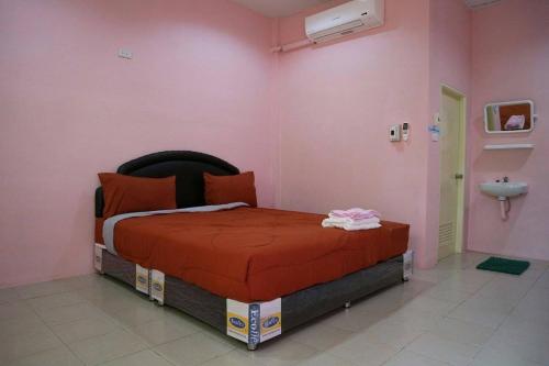Ban Nong Tumอวบอิ๋มรีสอร์ท #ที่พักภูกระดึง的粉红色客房内的一间卧室,配有一张床