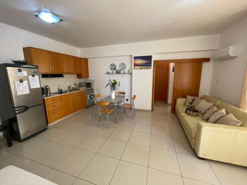 拉纳卡VIP Resort Apartment on Makenzie Beach的客厅以及带沙发和桌子的厨房。