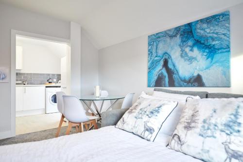 大雅茅斯homely - Great Yarmouth Beach Apartments的白色卧室配有床和桌子