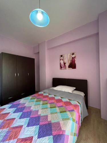 乐托卡亚Olympian Two Floor Apartment的一间卧室配有一张带五颜六色被子的床