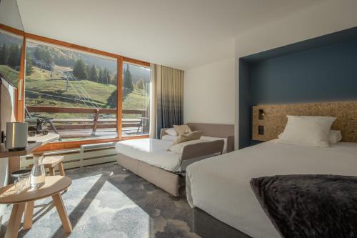阿克 1600La Cachette, Friendly Hotel & Spa的酒店客房设有两张床和大窗户。