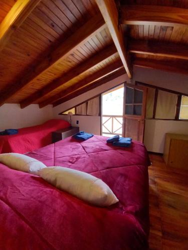 卢汉德库约Casa La Encantada, en el pedemonte mendocino的一间卧室,在红色的床上配有两个枕头