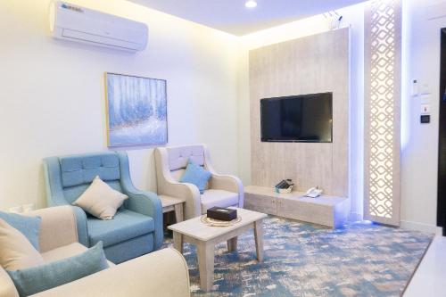 艾卜哈فندق واي هوتل的客厅配有蓝色椅子和电视