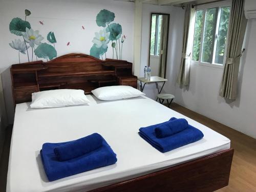 帕他仑Tree in town ทรีอินทาวน์的一间卧室配有一张带两个蓝色枕头的床