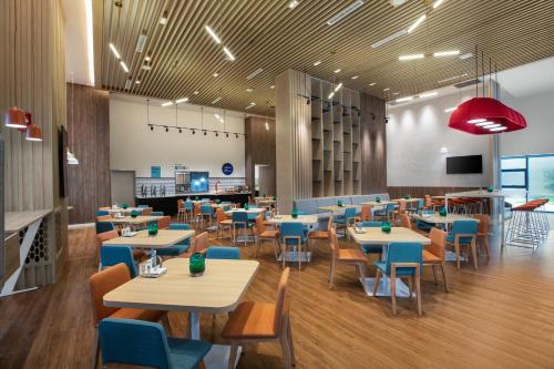 贵阳贵阳青岩智选假日酒店的一间配备有桌子和蓝色椅子的用餐室