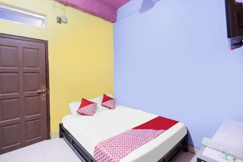 名古屋SPOT ON 91887 Penginapan Rindu的一间小卧室,配有一张床和一扇门