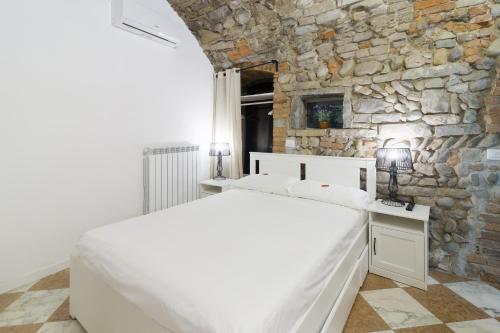 贝加莫BERGAMO art的卧室配有白色的床和石墙