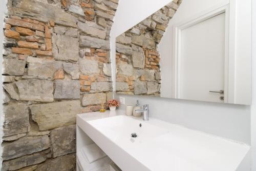 贝加莫BERGAMO art的浴室配有白色水槽和石墙