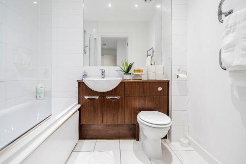 巴塞尔顿2-Bed Apartment Near Basildon Train Station的浴室配有盥洗盆、卫生间和浴缸。