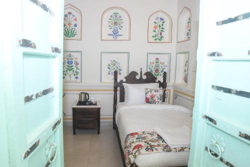 布什格尔KothiPushkar的一间卧室配有一张床,墙上挂着一些图片