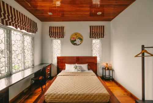 顺化Le Robinet Villa - a journey into Hue citadel soul的一间设有床铺的卧室,位于带窗户的房间内