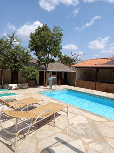 皮雷诺波利斯Brisa da Serra Hotel Pousada Pirenopolis的别墅设有游泳池和庭院家具。