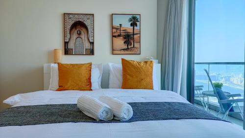 迪拜Exquisite, luxe 1BD Apartment, Unparalleled Sea Views, Prime Dubai Marina Location & Full Kitchen by "La Buena Vida Holiday Homes的一间卧室配有一张带两个枕头的床