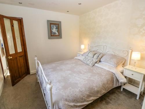 索厄比布里奇Prospect Cottage的卧室配有带枕头的白色床和门。