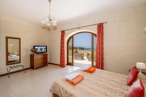 圣劳伦斯The Olives Holiday Home的一间卧室设有一张床、一台电视和一个窗口。
