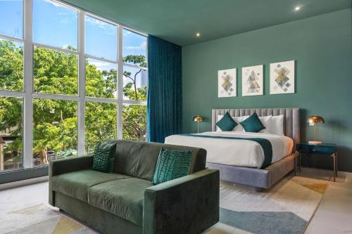 圣胡安Don Rafa Boutique Hotel & Residences的一间卧室配有一张床、一张沙发和窗户。