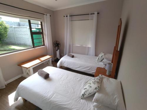 Glen Eden2 Bedroom Guest Suite at A-frame Glengariff Beach的带窗户的客房内的两张床