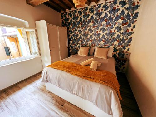 比萨San Ranieri Tiny Tower的一间卧室配有一张带花卉墙壁的床