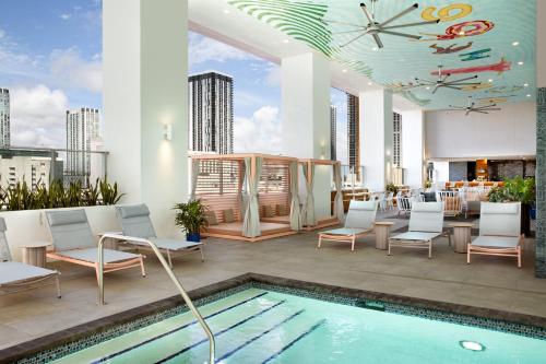 迈阿密YOTEL Miami的一座带游泳池和椅子的屋顶露台以及一座建筑