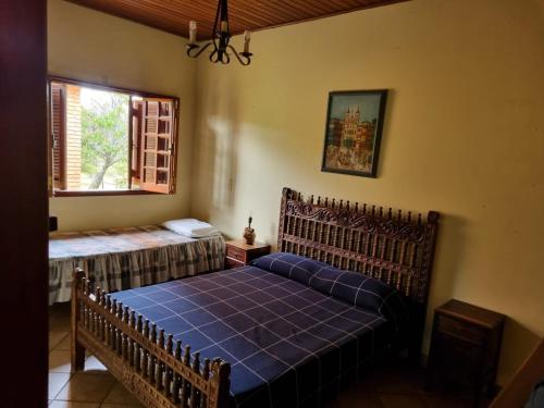 伊图Chacara Jequitiba的一间卧室设有蓝色的床和窗户。