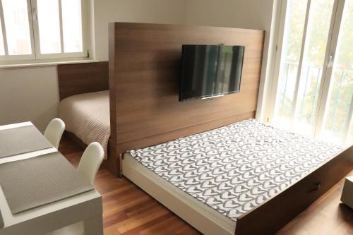 普图伊Studio apartma Terme Ptuj的小房间设有一张床和一台平面电视