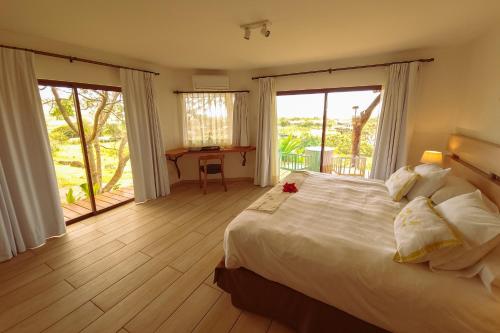 安加罗阿Hotel Hare Uta的一间带一张白色大床的卧室和一个阳台