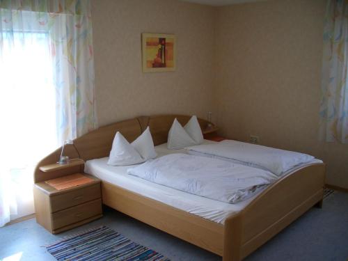 普福尔茨海姆Gasthaus Krone的卧室内的一张带白色床单和枕头的床