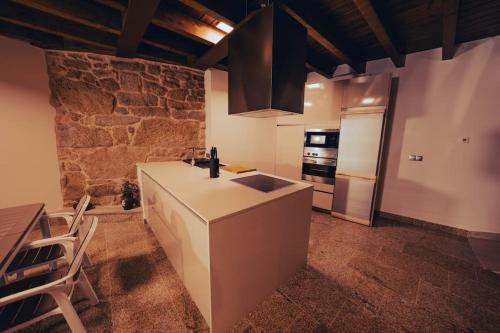 奥伦塞Casa Rural Vilar de Flores的一间带柜台和冰箱的厨房