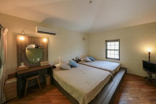 小笠原哲也旅馆的一间卧室配有两张床、一张桌子和一面镜子