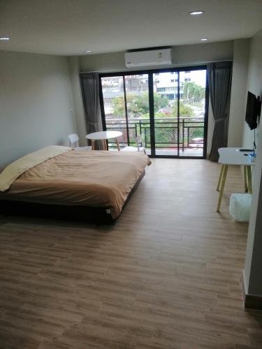 合艾IHome Hatyai的一间卧室设有一张大床和一个大窗户
